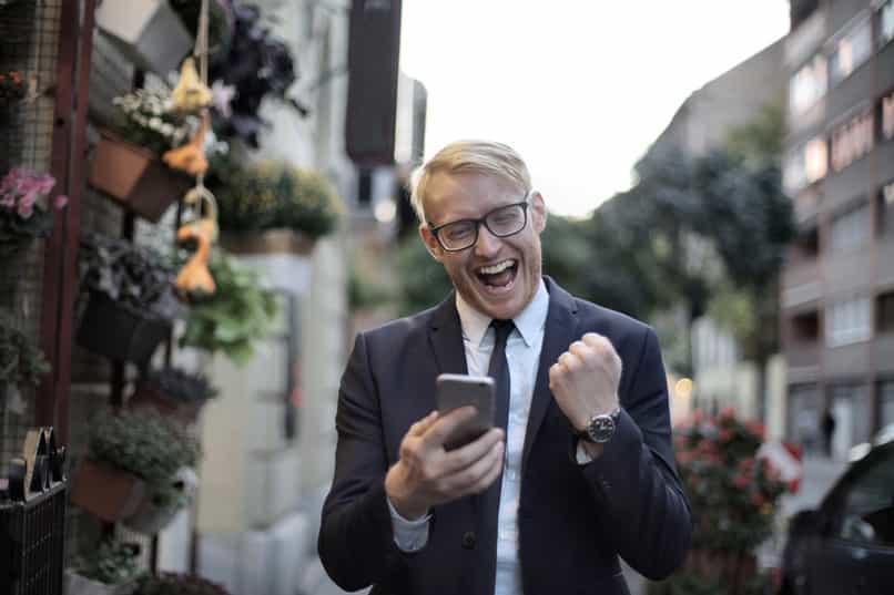 onnellinen mies lähettää pyynnön rahaa skype-sovelluksella matkapuhelimesta