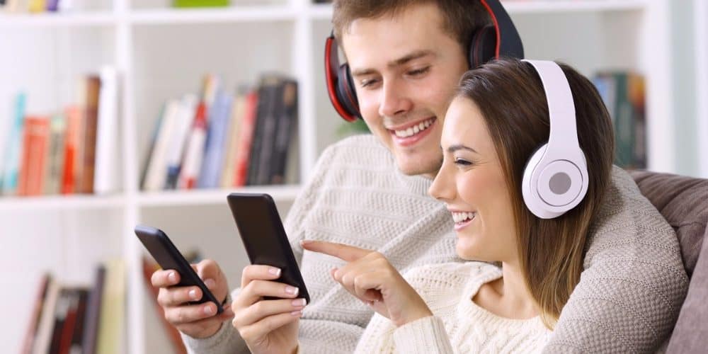 couple listening to music headphones mobile featured