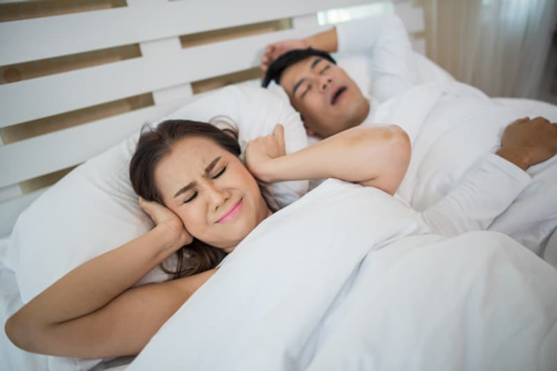 mujer bloqueando orejas hombre durmiendo ronquidos 12855