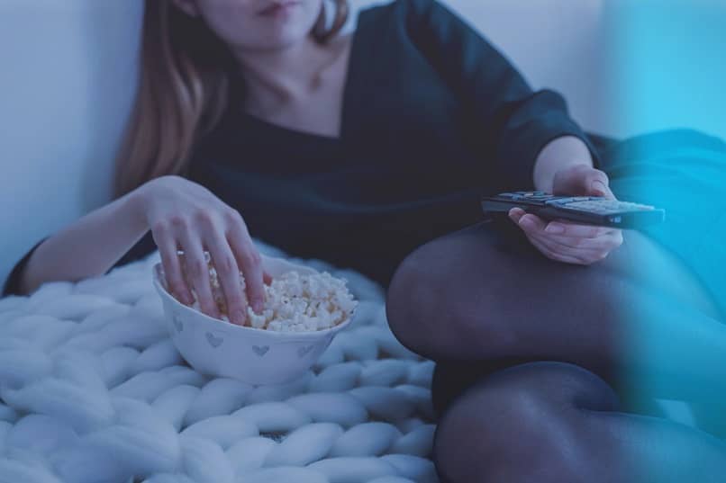 mujer viendo TV comiendo palomitas maiz