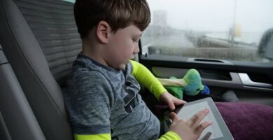 nino sentado carro usando tablet