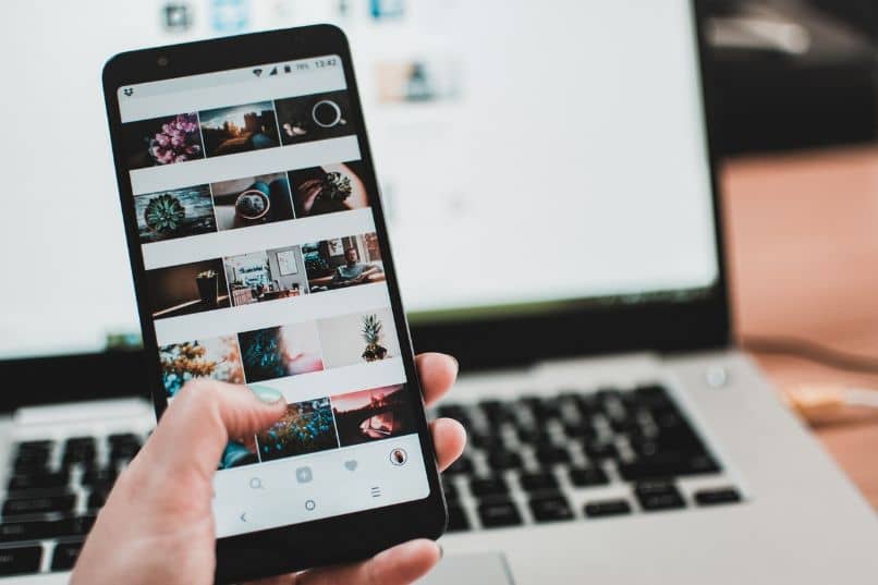 instagram älypuhelimessa kannettavalla tietokoneella ja kädellä