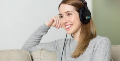 mujer sentada escucha audifonos