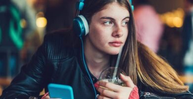 teenage girl listening music phone featured 1000x500