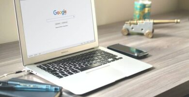 lapto navegador google sobre escritorio gris movil negro
