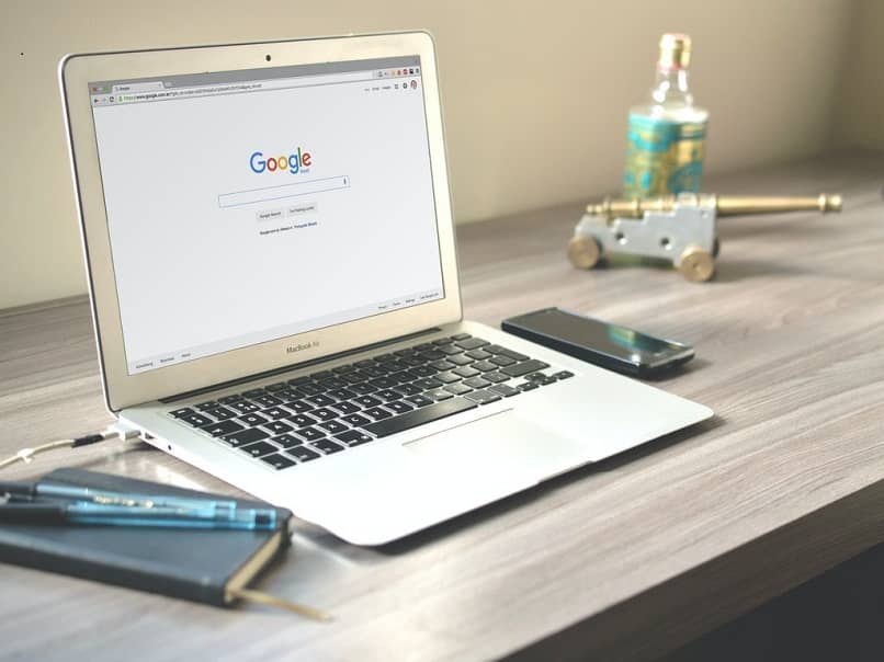 lapto navegador google sobre escritorio gris movil negro