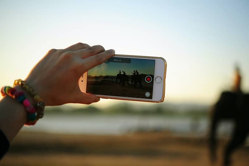 mano sosteniendo telefono tomando foto