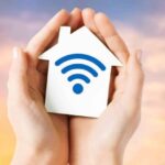 manos con figura de casa con simbolo wifi