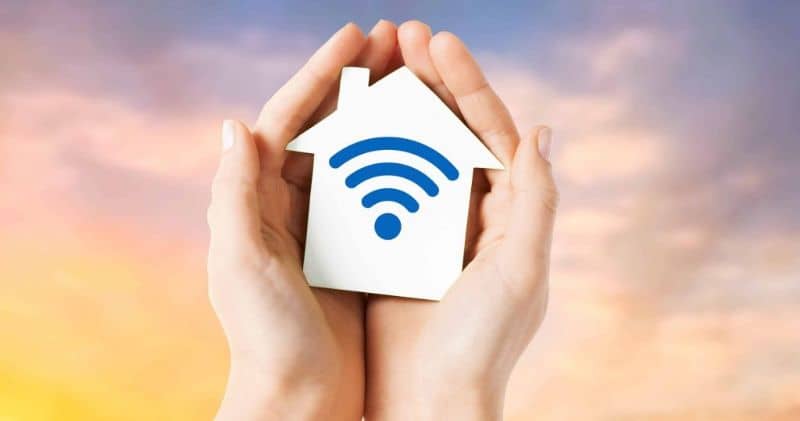 manos con figura de casa con simbolo wifi