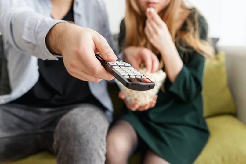 pareja sofa comiendo palomitas viendo tv