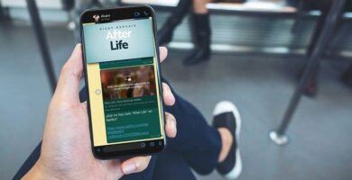 persona sentada cuzando piernas sostiene mano celular aplicacion after life