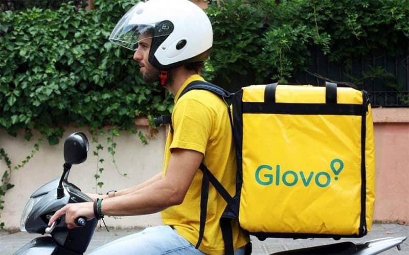 Työntekijä toimittaa glovo -paketin