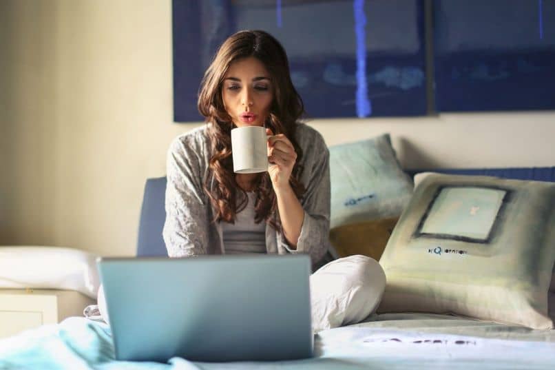 mujer lptop tomando cafe