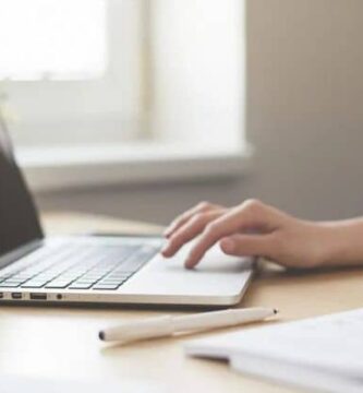 mujer maneja laptop sobre una mesa