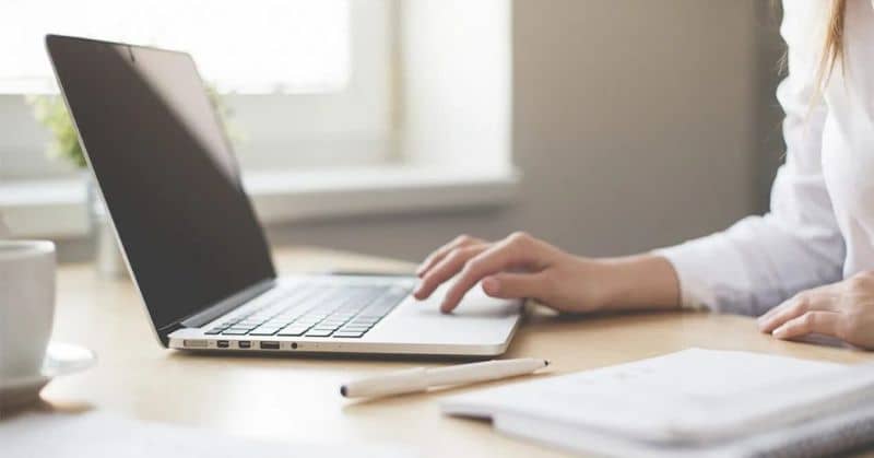 mujer maneja laptop sobre una mesa