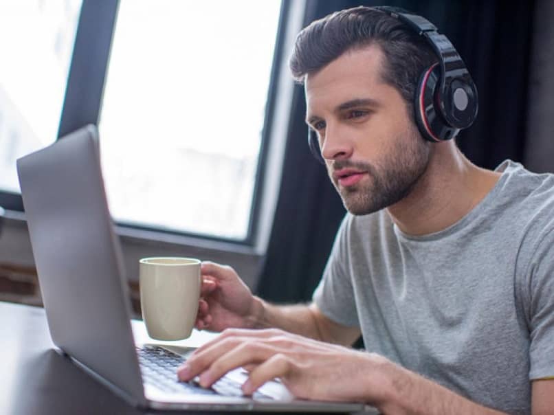 persona auriculares tecleando