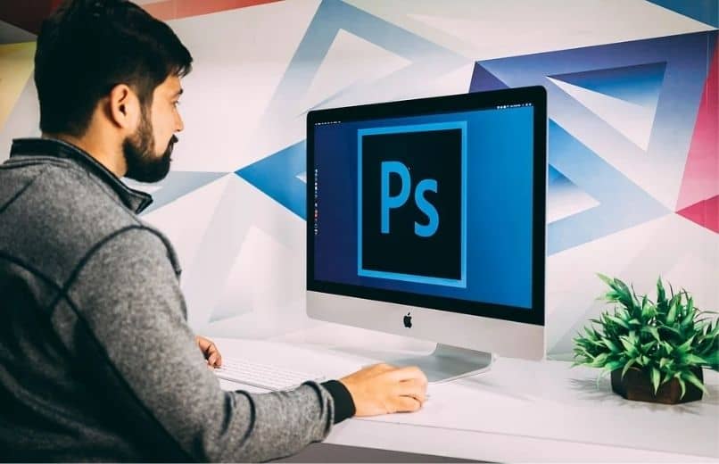 mies käyttää photoshop-ohjelmaa