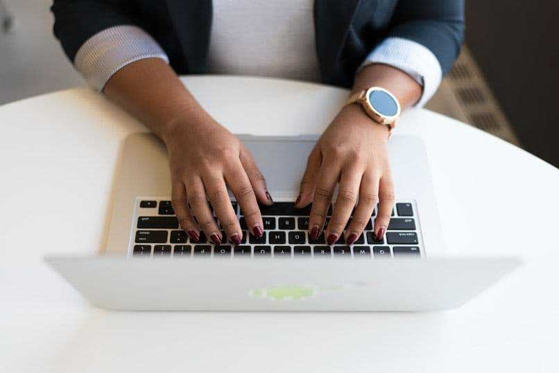 nainen käyttää kannettavaa tietokonetta